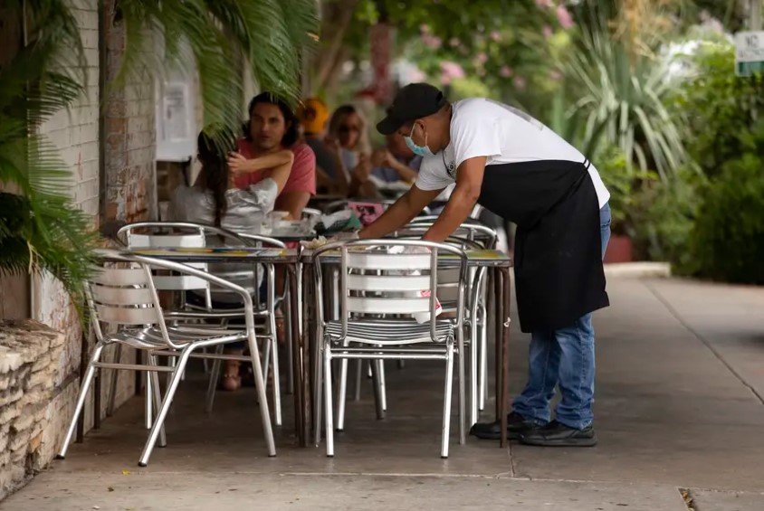 Texas collected $2.98 billion in sales tax revenue in July — 4.3% more than in July 2019. Comptroller Glenn Hegar said the number was "better than expected." In this photo, an employee cleans a table at Gueros Taco Bar in South Austin. Restaurants contribute to sales tax revenue.